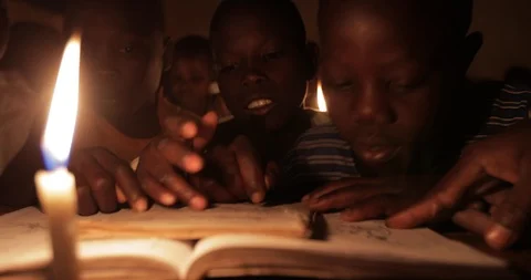 Students Studying in a class by candlelight and kerosene lantern in Mbale . Stock Footage 119153594
