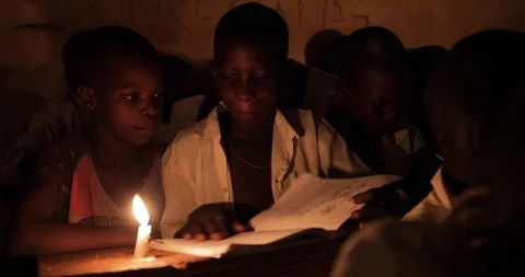 Students Studying in a class by candlelight and kerosene lantern in Mbale . Stock Footage 119153851