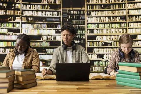 Students studying quietly with laptop, notes and books in library 写真素材