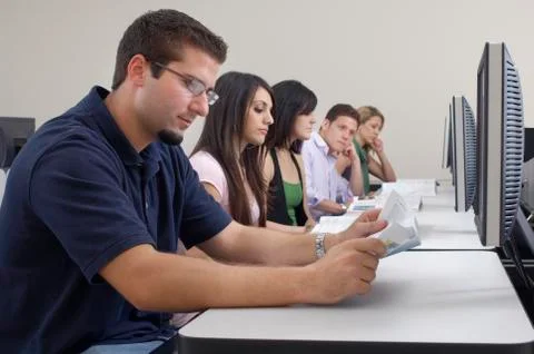 Students Studying While Sitting In Computer Lab Stock Photos