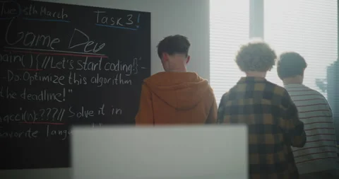 Students in Sun Filled Classroom Discuss Game Development Projects Stock Footage 318523719