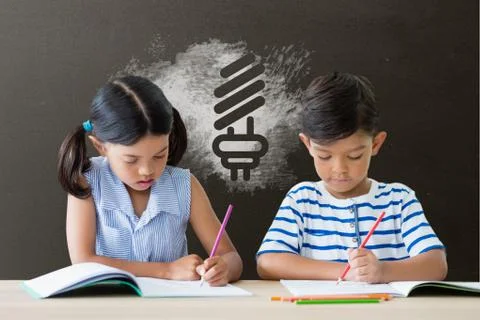 Students at table writing against grey blackboard with school and education Stock Photos