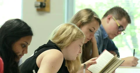 Students taking notes and doing their assignments in class. Ultra HD 4K Stock Footage 44739580