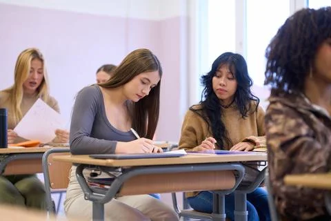 Students taking notes during lesson in classroom at university or college Stock Photos