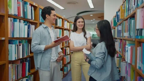 Students talking together for project knowledge and planning research in library Stock Footage 320040640