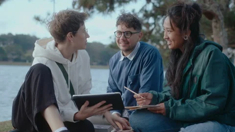 Students Using Digital Tablet and Talking in the Park Stock Footage 237056171