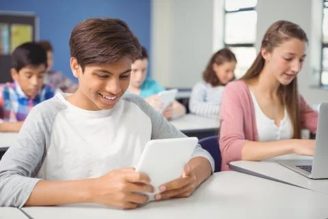 Students using digital tablet and laptop in classroom 스톡 사진