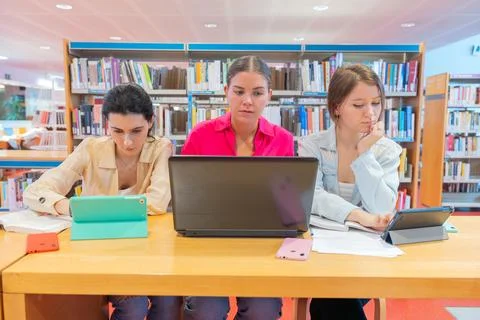 Students using laptops and tablets for study in library Stock Photos