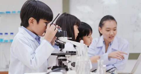Students using microscope to research with science project. Stock Footage 114720637