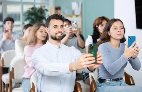 Students using mobile phones to scan QR code during interactive lesson Fotos de archivo