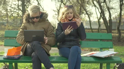 Students using modern technology in the autumnal park Stock-Footage 57891513