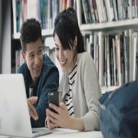 Students using smartphone in library Stock Footage 69432593