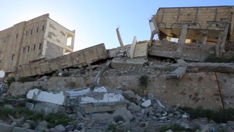 Students walk by their school, destroyed by the violent war in Yemen Vídeo Stock 197048437