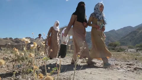 Students walk by their school, destroyed by the violent war in Yemen Stock Footage 197048445