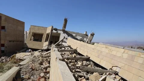 Students walk by their school, destroyed by the violent war in Yemen Stock Footage 197048507