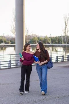 Students walking on campus path laughing together Stock Photos