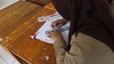 Students wearing hijabs, drawing patterns of fashion sleeves. pen and ruler. Stock-Footage 243626499