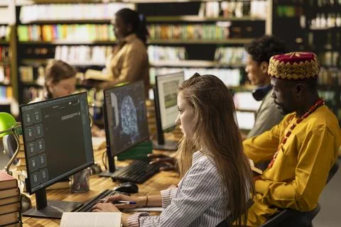 Students work at desktop with AI learning screens and digital study tools Foto stock