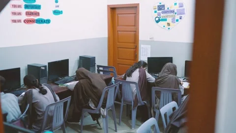 Students work on desktop computers in a school computer lab in Karachi Stock Footage 329224287