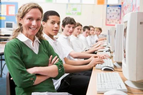 Students working on computer workstations with teacher Stock Photos