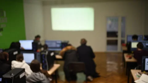 Students working on computers in classroom with teacher guidance Stock Footage 332620865