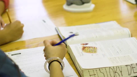 Students write in a worksheet during class Stock Footage 130587971