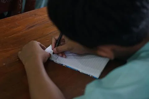Students writing and recording learning outcomes given by the teacher in clas Stock Photos