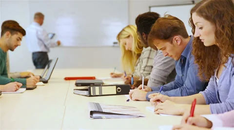 Students writing in classroom Stock Footage 32816625