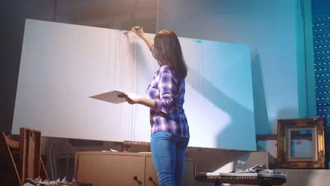 Studio artwork under the dim illumination, female painter creating abstract Stockbeeldmateriaal 230625388