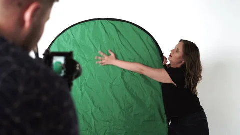 Studio backstage, female actress make hand motion standing on a green background Stock Footage