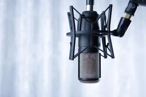 Studio black condenser microphone against gray curtains Stock-Fotos