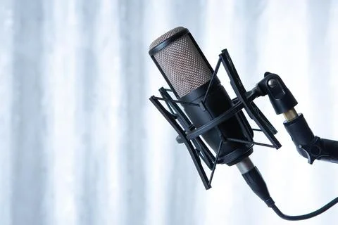 Studio black condenser microphone against gray curtains Stock-Fotos