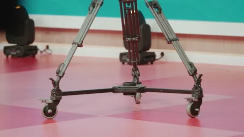 Studio camera dolly wheels on tripod during indoor production setup Video stock 328929249