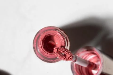 Studio close-up of a partially used pink nail polish bottle with brush, dried Stock Photos