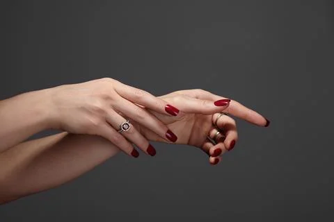 Studio close-up of two hands with glossy red manicure against on nails Stock Photos
