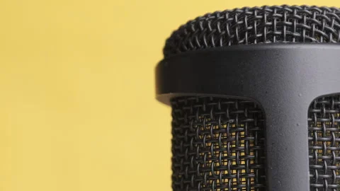 Studio Condenser Microphone Rotates on Yellow Background with Place for Text Stock Footage 146654946