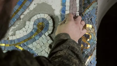 Studio craftsperson corrects vertical rows of ceramic mosaic Video stock 146254750