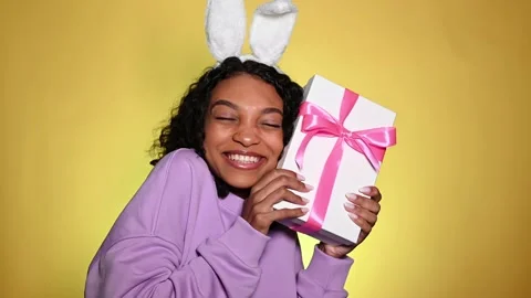 Studio easter portrait of african american smiling and hugging gift box. Stock Footage 236472458