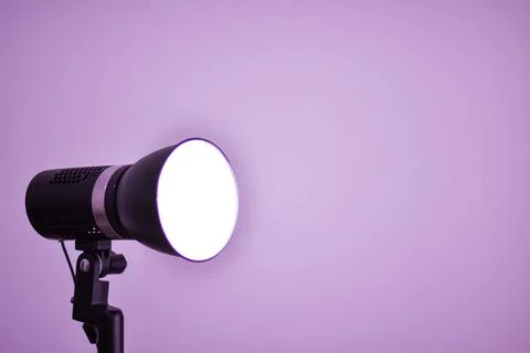 Studio flash light on a tripod stand isolated on very peri background 스톡 사진