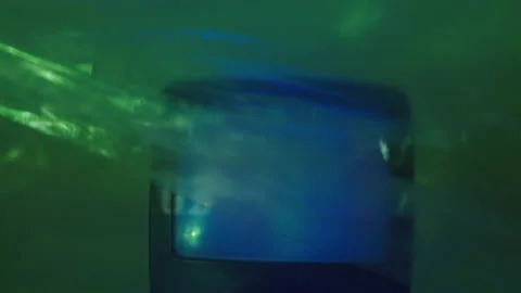 In a studio with a green light, the TV plays static, and a transparent sheet Stock Footage 132899711