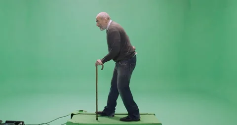 Studio, green screen, a casually dressed senior man with a cane on a treadmill Stock Footage 140518278