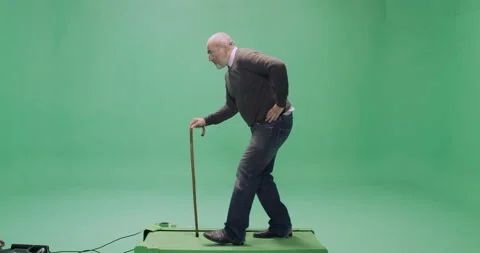 Studio, green screen, a casually dressed senior man with a cane on a treadmill Stock Footage 140518376