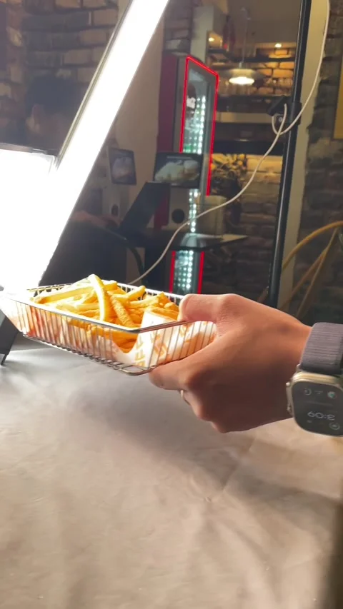 Studio image displaying rough brick backdrop accompanied by fries and cell phone Stock Footage 335435001