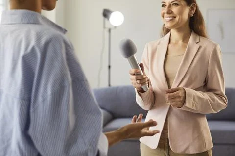 Studio interview recording, dialogue of smiling female journalist with 库存照片
