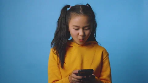 The studio isolated footage of the girl using a smartphone Vídeos de archivo 232589722