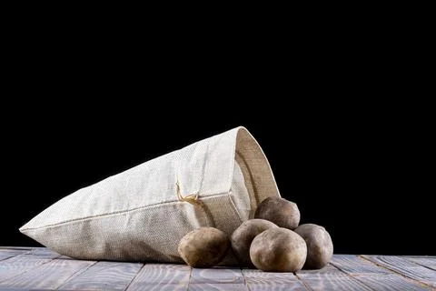 Studio lighting. black background. potatoes are planted from a bag on a retro Stock Photos