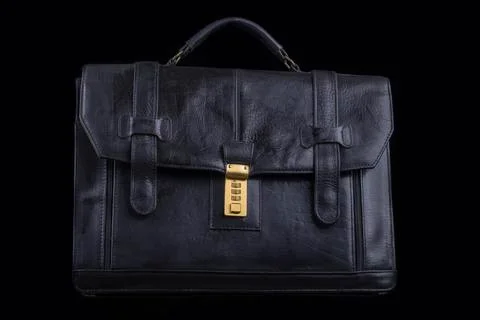 Studio lighting. dark background. Black briefcase in retro style. Close-up. Stock Photos