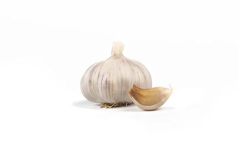Studio lighting. A head of garlic and a small slice on a white background. Cl Stock Photos