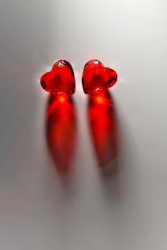 Studio mage of Two Sparkling Red Gemstone Hearts on a Grey Studio Background Stock Photos