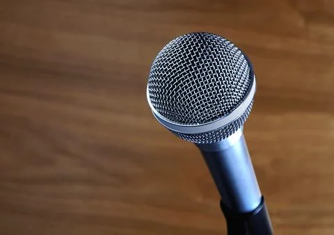 Studio microphone against a wood background. Stock Photos
